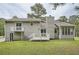 Back exterior view of the home features a deck, patio, and a well-manicured lawn with mature trees at 1945 Chateau Ln, Lithia Springs, GA 30122