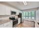 Well-lit kitchen features white cabinets, granite countertops, stainless steel appliances and wood-look flooring at 1945 Chateau Ln, Lithia Springs, GA 30122