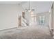 Bright living room featuring neutral walls and carpet, white trim, and a staircase to the upper level at 1945 Chateau Ln, Lithia Springs, GA 30122
