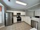 Bright kitchen with stainless steel appliances, white cabinets, and tiled floor at 4645 Valais Ct # 121, Alpharetta, GA 30022