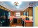 Charming kitchen with dark appliances, warm wood cabinets, and a view to the front yard at 154 Weatherly Way, Alpharetta, GA 30009