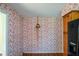 Small room showcases floral wallpaper, wood floors, and view into the kitchen and outdoor area at 154 Weatherly Way, Alpharetta, GA 30009