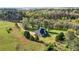 Peaceful aerial view of a two-story home with a lush green lawn, mature trees, and a charming fenced yard at 240 Indian Creek Rd, Locust Grove, GA 30248