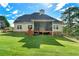 A serene backyard featuring a charming screened porch, stairs, and a lush green lawn at 240 Indian Creek Rd, Locust Grove, GA 30248