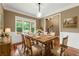Inviting dining room with hardwood floors, wainscoting, and a rustic wooden table at 240 Indian Creek Rd, Locust Grove, GA 30248