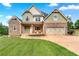 Inviting two-story home with a stone and siding exterior, two-car garage, covered porch, and professionally landscaped yard at 240 Indian Creek Rd, Locust Grove, GA 30248