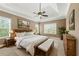 Comfortable primary bedroom featuring a tray ceiling and plenty of natural light at 240 Indian Creek Rd, Locust Grove, GA 30248