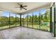 Relaxing screened porch featuring an outdoor ceiling fan, black railing, and a view of the spacious backyard at 240 Indian Creek Rd, Locust Grove, GA 30248