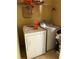Functional laundry room with a washer, dryer, storage shelves, and beige walls at 5009 Duval Point Sw Way, Snellville, GA 30039