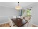 Dining room with seating for six, a sliding glass door to the outside and contemporary light fixture at 6810-G Glenridge Dr, Atlanta, GA 30328