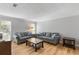 Spacious living room showcasing hardwood floors, neutral walls, and comfortable gray sofas with blue accent pillows at 6810-G Glenridge Dr, Atlanta, GA 30328