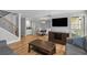 Open-concept living area features hardwood floors, a flat screen television, staircase, and view into dining area at 6810-G Glenridge Dr, Atlanta, GA 30328