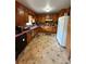Functional kitchen with classic wooden cabinets and tiled floors at 6957 Mason Creek Rd, Douglasville, GA 30135