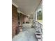 View of a covered porch with potted plants and brick facade, perfect for outdoor enjoyment at 6957 Mason Creek Rd, Douglasville, GA 30135