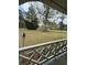 Inviting front porch view of the expansive yard and mature trees beyond the lattice railing at 6957 Mason Creek Rd, Douglasville, GA 30135