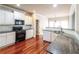 Bright kitchen boasts hardwood floors, granite counters, and modern white cabinets at 1209 Richmond Rdg, Loganville, GA 30052