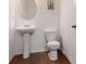 Half bathroom with pedestal sink, hardwood flooring, and toilet at 121 Shoals Bridge Rd, Acworth, GA 30102