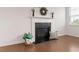 Cozy living room featuring a charming fireplace, elegant mantle, and hardwood floors at 121 Shoals Bridge Rd, Acworth, GA 30102