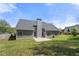 Large, grassy backyard with a grey home, a patio, and a wooden privacy fence at 2232 Ann Ln, Lithia Springs, GA 30122