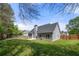 Large, grassy backyard featuring a grey home, patio, and wooden privacy fence at 2232 Ann Ln, Lithia Springs, GA 30122