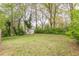 Lush backyard featuring a shed and mature trees providing shade and privacy at 2460 Constance St, East Point, GA 30344
