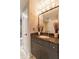 The bathroom has a granite countertop, decorative mirror, vanity, and gray tiled floor at 2626 Peachtree Nw Rd # 412, Atlanta, GA 30305