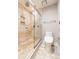 This bathroom includes a glass-enclosed shower with travertine tile and an upgraded toilet at 2626 Peachtree Nw Rd # 412, Atlanta, GA 30305