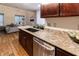 Kitchenette featuring dark wood cabinets, granite counters, stainless dishwasher, and wooden floors at 2626 Peachtree Nw Rd # 412, Atlanta, GA 30305