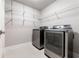 A modern laundry room features stainless steel appliances and white wire shelving for organization and convenient storage at 2626 Peachtree Nw Rd # 412, Atlanta, GA 30305