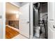 A utility closet with exposed HVAC elements is shown next to a living space with hardwood floors and a black railing at 2626 Peachtree Nw Rd # 412, Atlanta, GA 30305
