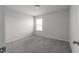 A clean, carpeted bedroom with a window that provides natural light at 4171 Dean Grove Way, Loganville, GA 30052