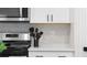 A well-appointed kitchen featuring white cabinets, stylish backsplash, and stainless steel appliances at 4171 Dean Grove Way, Loganville, GA 30052