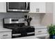 Close-up of a modern kitchen with stainless steel appliances and stylish backsplash at 4171 Dean Grove Way, Loganville, GA 30052