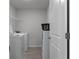 A dedicated laundry room featuring a modern washer and dryer with shelving for storage at 4171 Dean Grove Way, Loganville, GA 30052
