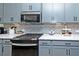 Modern kitchen featuring gray cabinets, quartz countertops, stainless steel appliances, and gas range at 1433 Halpern Ln, Kennesaw, GA 30144