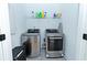 Efficient laundry room with modern stainless steel washer and dryer units, plus extra storage at 1433 Halpern Ln, Kennesaw, GA 30144