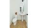This powder room features a pedestal sink, toilet, and light fixture at 1433 Halpern Ln, Kennesaw, GA 30144