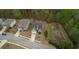 Bird's eye view shows the house, driveway, and surrounding neighborhood, plus wooded green space behind the property at 164 Madison Grace Ave, Mcdonough, GA 30252