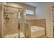 Tiled bathroom featuring a glass-enclosed shower and a soaking tub at 164 Madison Grace Ave, Mcdonough, GA 30252