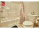 Bright bathroom with white tiled shower and toilet with decorative accents and storage at 164 Madison Grace Ave, Mcdonough, GA 30252