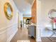 Bright hallway featuring hardwood floors, decorative mirrors and wall trim, leading to living spaces at 164 Madison Grace Ave, Mcdonough, GA 30252