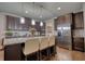 Bright kitchen with stainless steel refrigerator, granite countertops, breakfast bar, and dark wood cabinetry at 164 Madison Grace Ave, Mcdonough, GA 30252