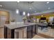 Kitchen island with pendant lighting overlooks entertainment area with pool table and bright yellow wall at 164 Madison Grace Ave, Mcdonough, GA 30252