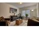 Cozy living room features a large TV, comfortable seating, and a work area by the window at 164 Madison Grace Ave, Mcdonough, GA 30252