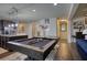 Open concept floor plan featuring pool table, kitchen, breakfast bar, and stainless steel refrigerator at 164 Madison Grace Ave, Mcdonough, GA 30252