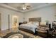 Well-lit main bedroom with tray ceilings, comfortable seating, and a view of the en suite bath at 164 Madison Grace Ave, Mcdonough, GA 30252