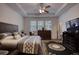 Bright main bedroom with a tray ceiling, large dresser, and view to the outdoors through big windows at 164 Madison Grace Ave, Mcdonough, GA 30252
