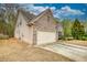 View of home featuring a brick and stone facade, two-car garage, and side yard at 164 Madison Grace Ave, Mcdonough, GA 30252