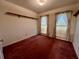Bedroom with carpet, two windows with curtains, and shelf along the wall at 204 Appalachee Church Rd, Auburn, GA 30011