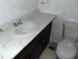 Bathroom featuring a toilet and vanity with marbled countertop and under-sink storage at 3695 Church St, Clarkston, GA 30021